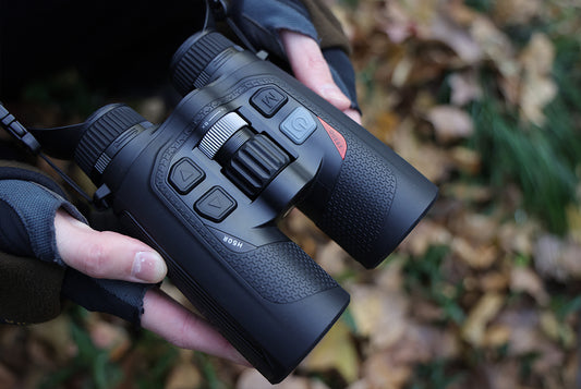  Black NocPix Quest H50R Thermal Imaging Binoculars held by a person with a natural background 